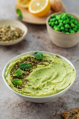 Hummus made of chickpeas, fresh green peas and mint, sprinkled with seeds