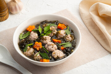 Thai style Clear seaweed soup with carrot ,Minced Pork ball and glass noodle in white bowl.(Gaeng...