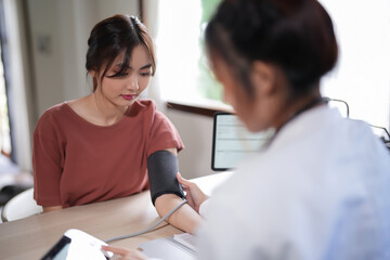 Asian psychologist women using digital sphygmomanometer to checking blood pressure and heart rate...