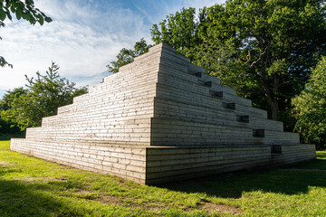 A big and creative wooden pyramid outdoors, modern public space, meeting place, recreational area