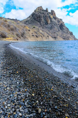 Kara-Dag, volcanic rocks near the Black Sea coast in the national park, rounded pebbles on the beach, Crimea