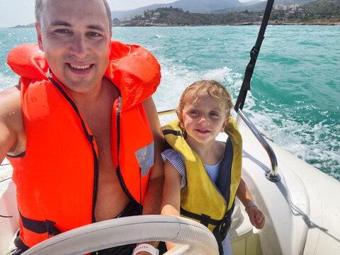 Father and his daughter enjoying a vacations boat ride at sea