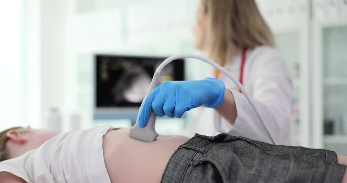 Ultrasound examination of child doctor makes scan of the abdomen of girl in medical clinic. Abdominal pain in child causes, diagnosis and treatment