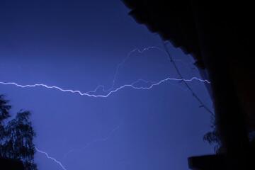 beautiful lightning during a thunderstorm at night in a forest that caused a fire, against a dark...