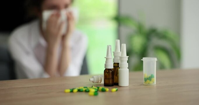 Treatment of cold flu and rhinitis with tablets and spray. Various medication sprays for stuffy nose and sore throat and person with napkin