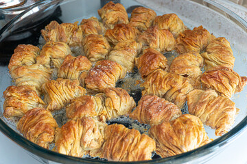Freshly baked baklava in a glass dish, golden and crispy, ready to be served.