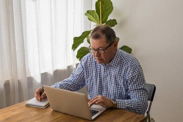 Senior man working on laptop in the home