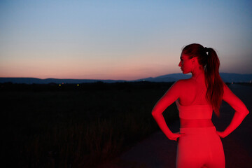  Athlete Strikes a Pose in Red-Lit Nighttime Glow