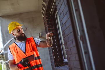 Portrait of successful man constructor wearing yellow helmet and safety yellow vest. Portrait of...