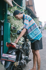 A motorcycle mechanic is checking a damaged engine