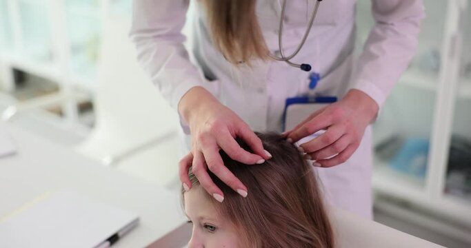 Closeup of female trichologist checking children hair. Parasites on the hair of a child and signs of pediculosis