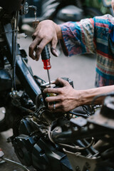 A motorcycle mechanic inspecting a damaged bikeA motorcycle mechanic is checking a damaged engine