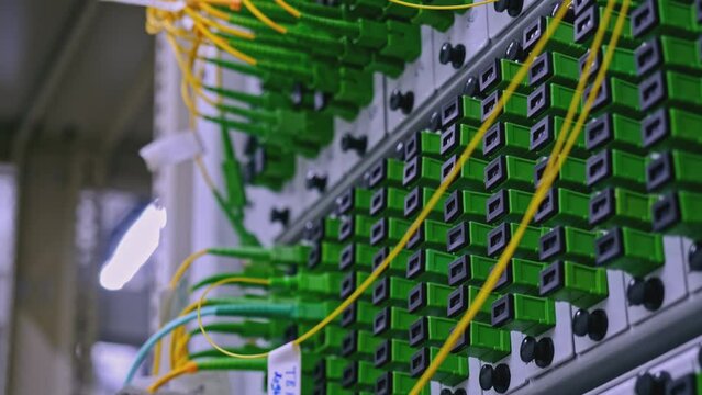 Close up of optical fiber switchboard hub in a server room. Stock footage. Concept of AI, internet, and modern technologies.