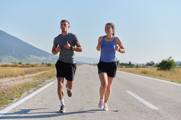 Energized by the beauty of nature, a couple powers through their morning run, their bodies and...