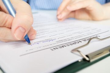 Divorce agreement, hand fills out a document, finalizing the breakup, legal paperwork, resolving...