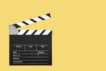 Cinema clapper board on a yellow background, copy space, cinematography symbol, action initiator,...