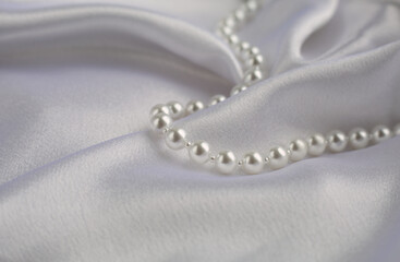 Beautiful background of white pearls on satin