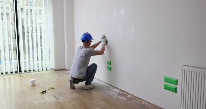 Plastering work on improvement of house and grinding surface of walls. Wall sanding and surface preparation for painting