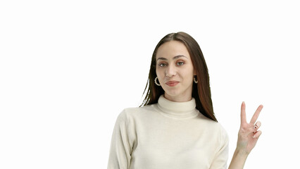 A woman, close-up, on a white background, shows a victory sign