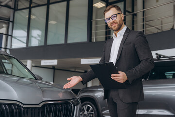 Happy salesman show car choice auto buy new automobile in showroom car dealership indoor
