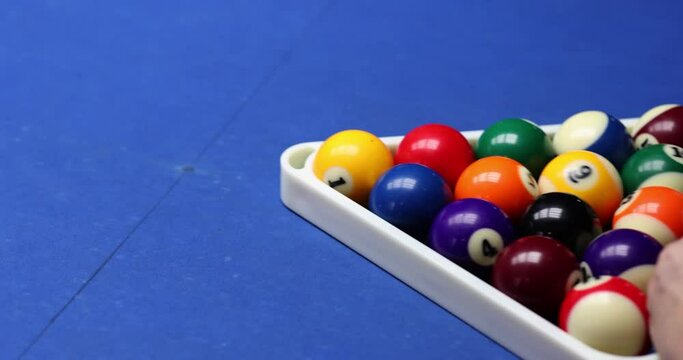 Person arranges bocce balls on pool table in bar. Billiards game