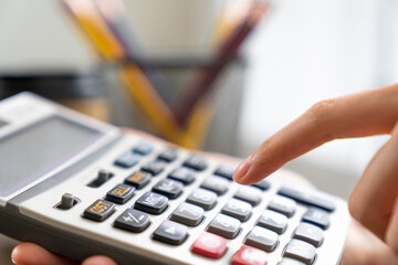 Hand holding calculator and calculate various expenses.