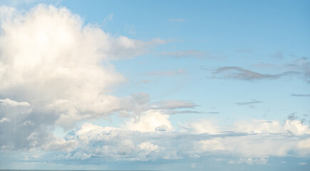 Serene blue sky with fluffy white cumulus clouds, thin cirrus streaks, peaceful day atmosphere,...