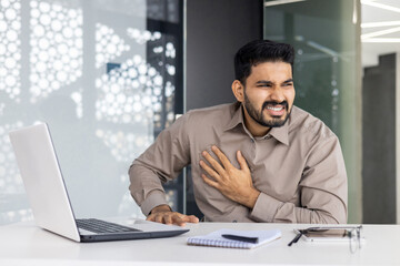 A man is experiencing chest pain in an office setting, indicating a serious health issue that requires immediate attention. Symptoms may include stress, discomfort, and heart problems