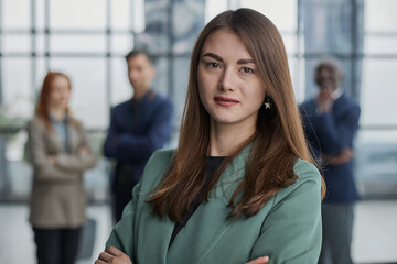 Portrait of a confident young businesswoman standing with her arms crossed in an office