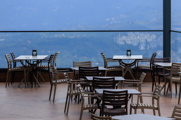 Beautiful views from above, tables in a cafe in the mountains and a panoramic view of the city, public places in Turkey, on a sunny summer day