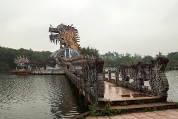 The once vibrant amusement park in ruins with towering dragon among the overgrown foliage....