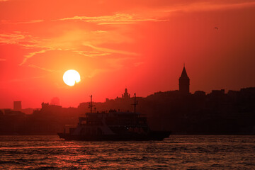 Naklejka premium Orange sky at sunset in the evening. Silhouette and outlines of the buildings. Evening views of buildings of the city of Istanbul.