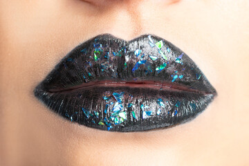 Close up view of beautiful woman lips with dark lipstick.