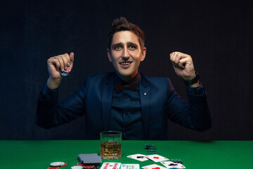Happy poker player winning with poker cards and chips.