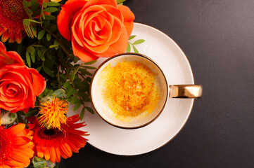 beautiful composition cup of coffee with flowers on a dark background