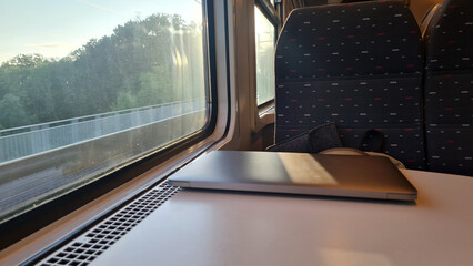 Working on the Go: Using a Laptop on a Train Journey with Scenic Views Outside the Window -...