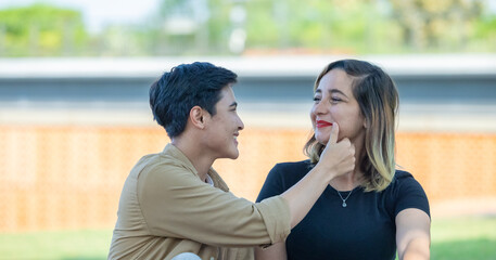 LGBT couple sharing romantic love and care in public, celebrating joyful union as life partners.