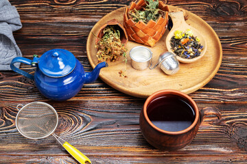 cup of herbal tea and ingredients on wooden table