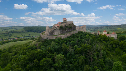 Rupea fortress in Romania. Amazing aerial view with blue sky with clouds. Trips to Transylvania. Medieval saxon landmark.