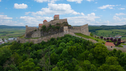 Rupea fortress in Romania. Amazing aerial view with blue sky with clouds. Trips to Transylvania.