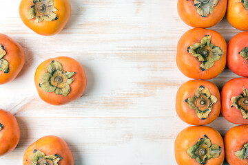 Delicious fresh persimmon fruits on wooden table.