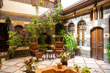 Interior of luxury hotel in oriental style with living plants and fountain in the lobby
