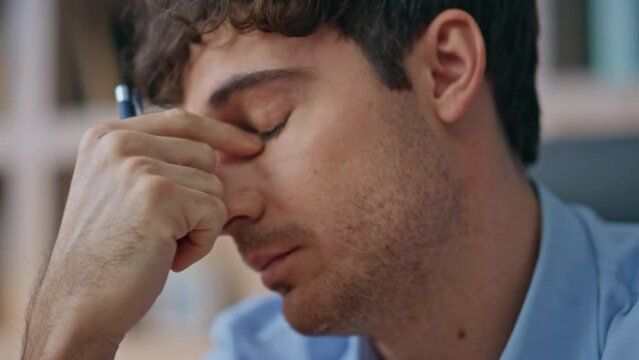 Businessman suffering eye strain overwork in office closeup. Tired man thinking