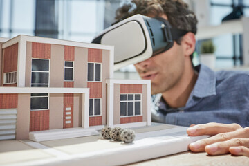 man sits in the office of a realtor and looks at the layout of the apartment in virtual reality glasses.