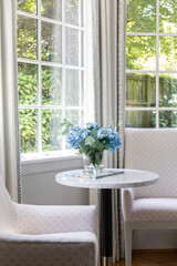 Cozy Intimate Seating Area with Flowers on Table Overlooking Gardens