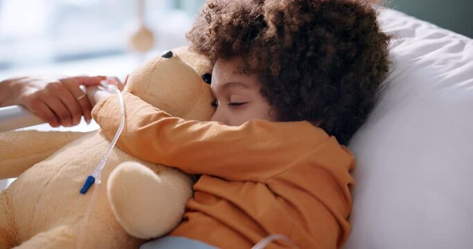 Boy, sleeping and teddy bear in hospital on bed for health, healthcare and medical support. Male child, nap and stuffed animal in clinic for wellness, cancer and medicine with chemotherapy in iv drip