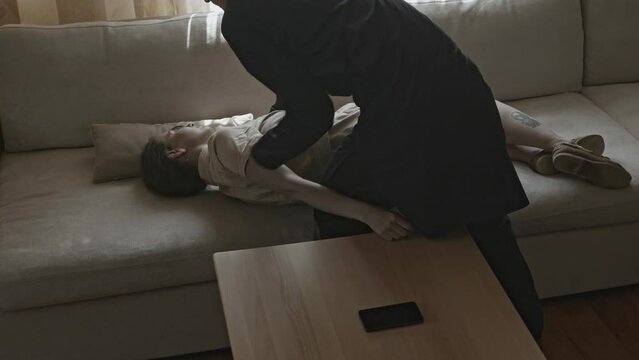 Man carrying unconscious woman in arms. Stock. Close-up of man carrying unconscious woman in arms. Man carries unconscious woman and puts her on sofa