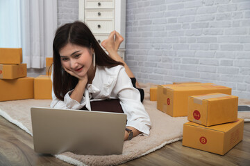 Successful entrepreneur business woman accepts orders from customer via online sales while lying on...