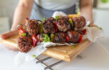 Delicious minced meat skewers with vegetables and potato wedges