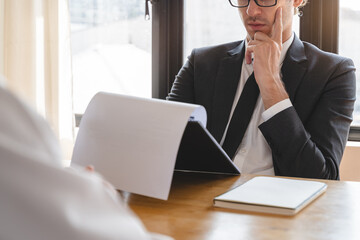 Close-up hands of interviewer on the table during asking question applicant in the office.